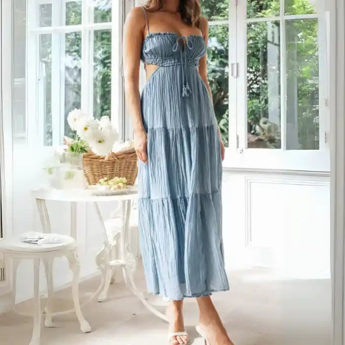 Dress in light blue with ruched front bodice, spaghetti straps, and flowing tiered skirt.