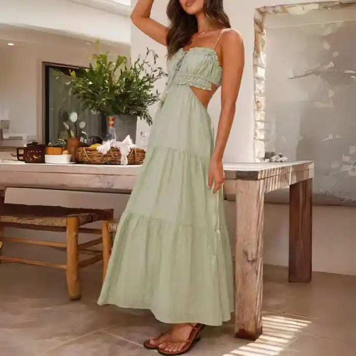 Dress in sage green with cutout waist, spaghetti straps, and tiered skirt for a summer boho look