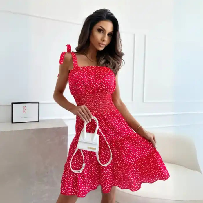  Dress in red polka dot midi style with smocked fit, flared skirt and white mini handbag accessory.