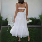 Dress in white with back tie straps and tiered flowing skirt, seen from behind.
