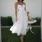 Dress with white tiered maxi cutout design, worn with heels in garden setting.