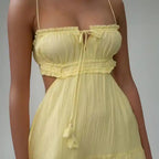 Dress close-up showing ruched bust, spaghetti straps, and tie detail in yellow