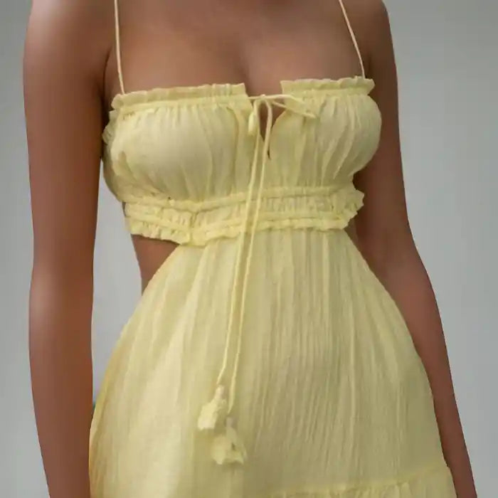 Dress close-up showing ruched bust, spaghetti straps, and tie detail in yellow