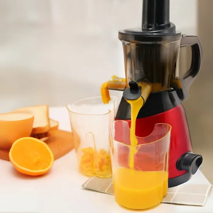 Slow juicer featuring separate juice and pulp outlets demonstrated with fresh orange juice extraction process