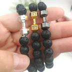 three dumbbell bracelets with lava beads and silver gold gunmetal charms held in hand