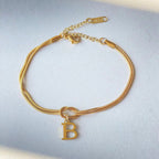 Gold bracelet with a letter 'B' charm on a light gray background