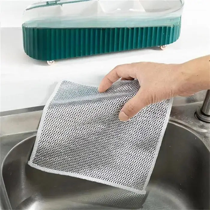 hand holding a mesh cleaning cloth over a stainless steel sink