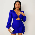 Electric blue sexy party dress styled with gold accessories and a white clutch, featuring a deep V-neckline and dramatic balloon sleeves.