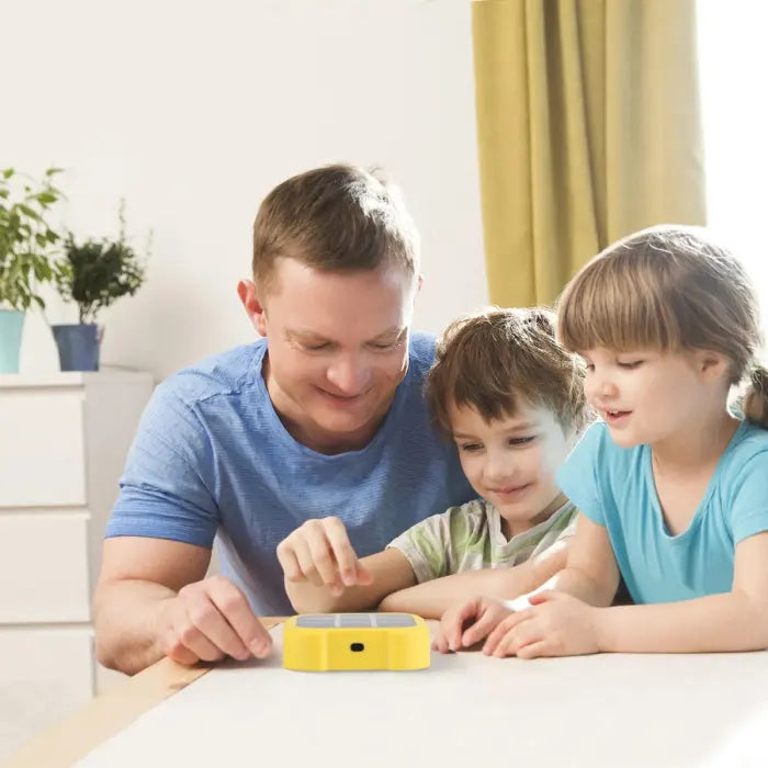 Family playing Electronic Tic-Tac-Toe Game together around a table in bright room.