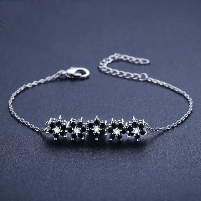 Silver bracelet with black floral design and adjustable chain for women’s fashion and jewelry trends.