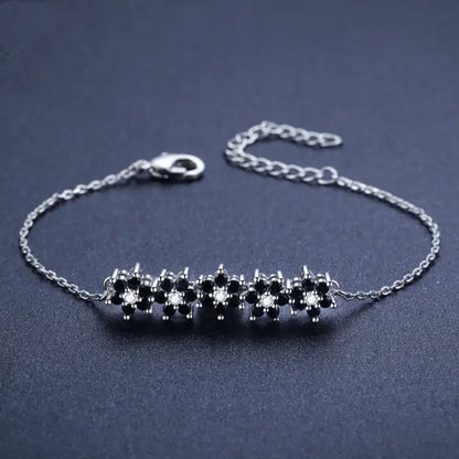 Silver bracelet with black floral design and adjustable chain for women’s fashion and jewelry trends.