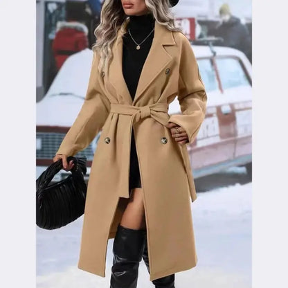 Stylish camel wool trench coat with belt tie, double-breasted buttons, and lapel collar worn with black boots and handbag