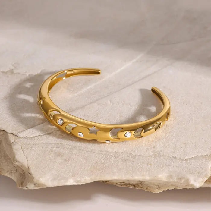 Elegant gold plated bangle with moon, star, and stone details, perfect for celestial-inspired jewelry lovers.