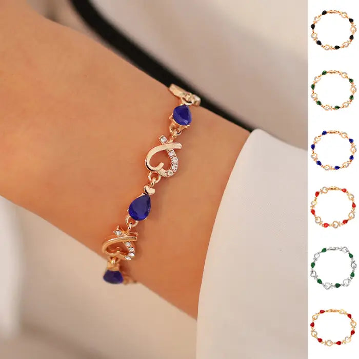 Elegant gold bracelet with blue gemstone teardrops and sparkling heart design, perfect for gifting.