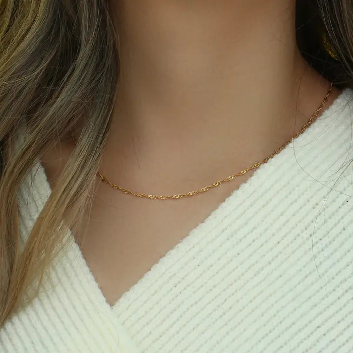 Elegant gold rope chain necklace worn with a white outfit, ideal for simple and chic jewelry lovers.