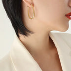 Classic gold hoop earring shown worn against neutral background