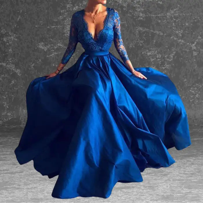 Model wears an elegant royal blue long sleeve evening gown with lace bodice, V-neck, full satin skirt. Shop similar formal dress styles.
