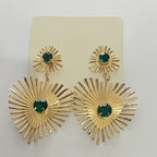 emerald sunburst statement earrings in gold presented on display card with bright green crystals and radiant, dramatic sunburst pattern