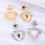 emerald sunburst statement earrings arranged in gold and silver, showcasing bright crystals and dramatic sunburst shapes for impact
