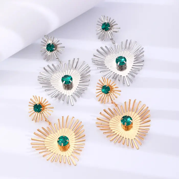 emerald sunburst statement earrings in gold and silver shown together, featuring radiant spokes and green stones for bold appeal