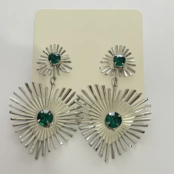 emerald sunburst statement earrings in silver displayed on card, highlighting bright green crystals and eye-catching sunray structure