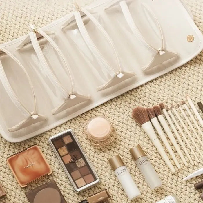 Empty makeup pouches with brushes and cosmetics neatly arranged for a complete makeup setup.