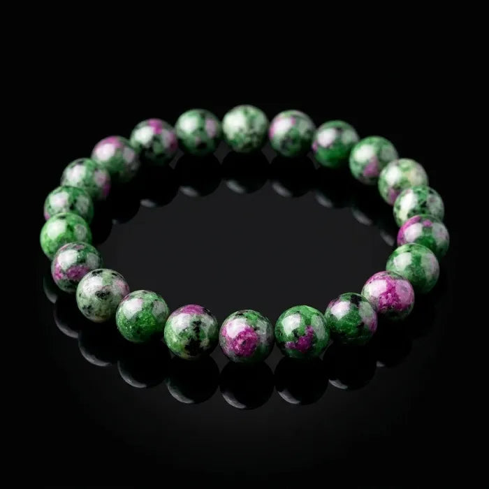 epitode bracelet displayed on black reflective surface with polished green and purple beads, luxury crystal jewelry for premium styling