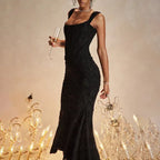 Evening dress in classic black featuring textured fabric, elegant square neckline and fitted silhouette perfect for gala events