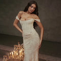 Evening dress in ivory with sophisticated off-shoulder design, structured corset bodice and figure-hugging silhouette for formal events