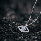 Evil eye protection necklace angled view on dark background highlighting fine chain and sparkling pendant.