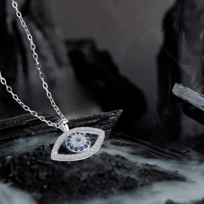 Evil eye protection necklace displayed artistically with silver chain and pendant over smoky background.