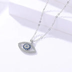Evil eye protection necklace closeup shot featuring sparkling crystals and silver chain on white background.