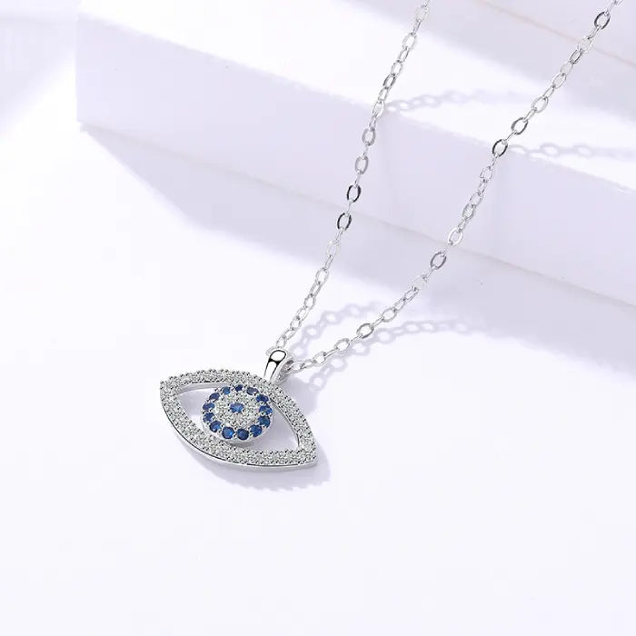Evil eye protection necklace closeup shot featuring sparkling crystals and silver chain on white background.