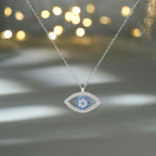 Evil eye protection necklace with shimmering blue stones photographed under glowing lights for luxury look.