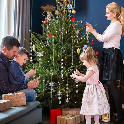 Family decorating Christmas tree together with crystal snowflake ornaments and wrapped presents beneath