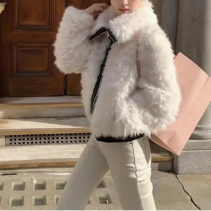 faux fur jacket, ivory cropped coat with black zip trim, paired with light pants, casual street look in daylight today..