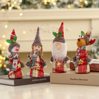 Four adorable Christmas gnome ornaments with red and plaid outfits, pointy hats, and festive designs on books