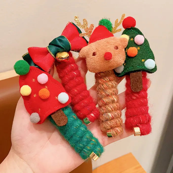 Close-up of Christmas hair rope with red and green bow and golden bell decoration.