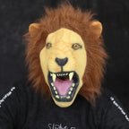 Front-facing adult lion mask showing open mouth, brown mane, and bared fangs.