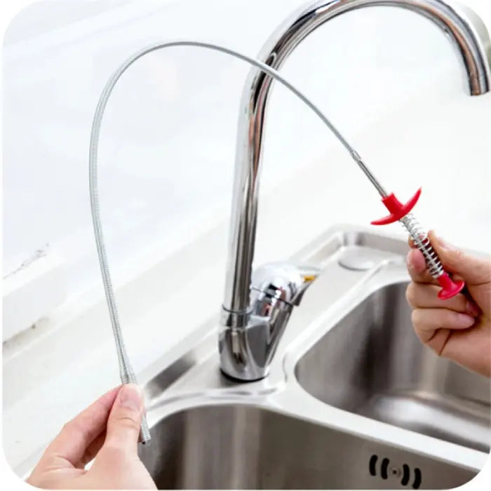 Flexible kitchen pipe dredging tool being used to clean a sink drain.