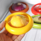 reusable lemon storage container with yellow lid showing flexible membrane keeping halved citrus fresh in clear close-up view