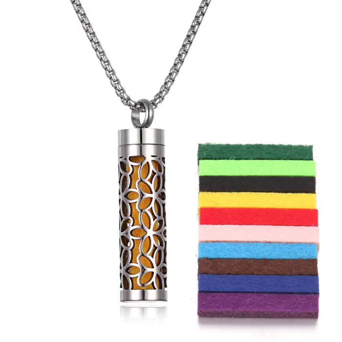 Floral design stainless steel aromatherapy pendant with yellow felt pad for essential oil diffusion.