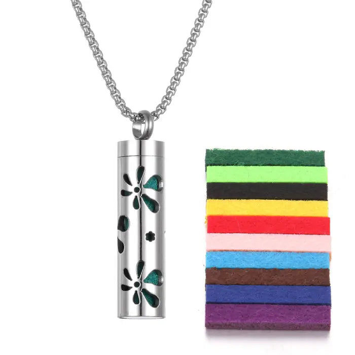 Stainless steel aromatherapy pendant with flower pattern and colorful felt pads for essential oil use.