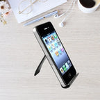 Foldable phone stand holding smartphone on light desk with pen, glasses, and coffee in background.
