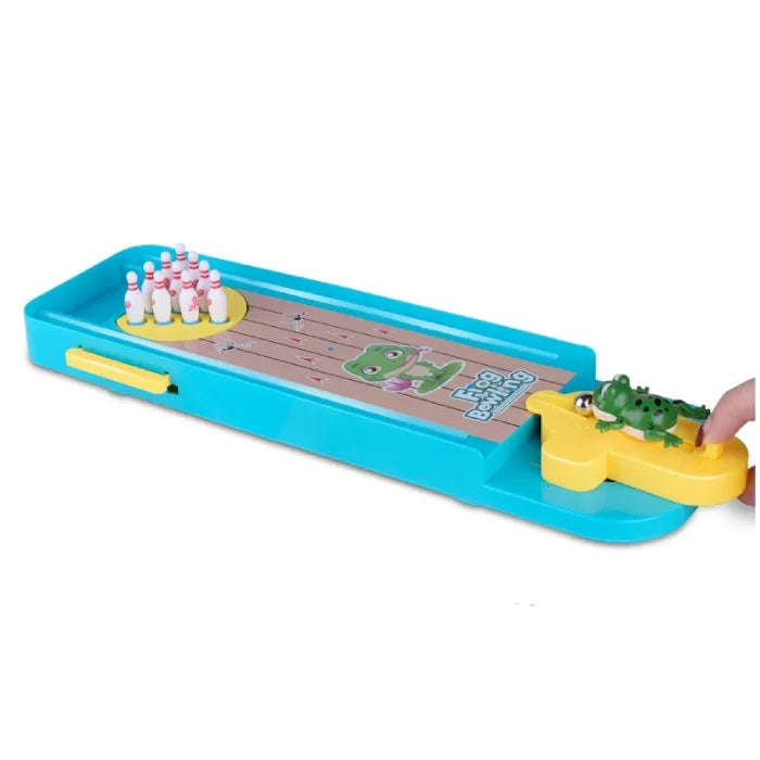 A frog-themed mini bowling game set with a blue base, yellow frog launcher, white pins with red accents, and metallic balls. Dimensions are labeled as 34 cm by 10 cm by 2.5 cm.