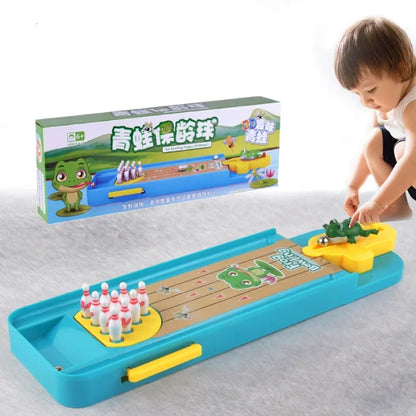 Child playing with a frog-themed mini bowling game featuring colorful pins and a fun launch mechanism.