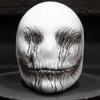Ghost latex mask in full front view on display, showing dripping black paint from eyes and mouth.