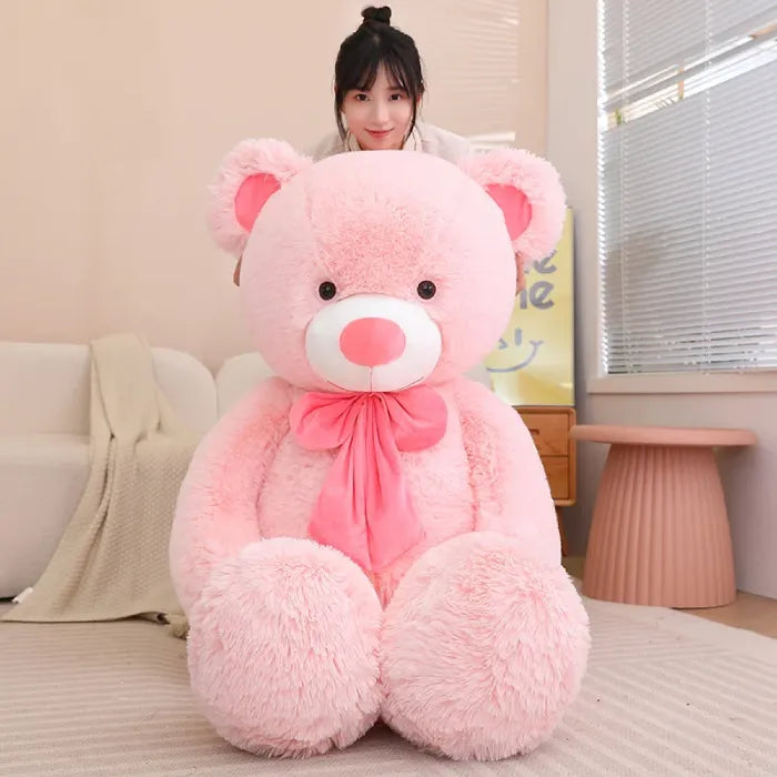 Young woman affectionately hugging a large white teddy bear indoors.