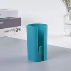 Gift wrap cutter in blue with visible blade opening and sturdy design shown on light gray surface.