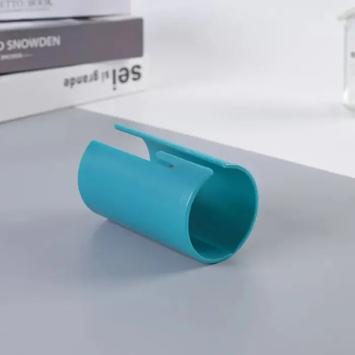 Gift wrap cutter in blue shown from side angle with smooth finish and curved blade housing.